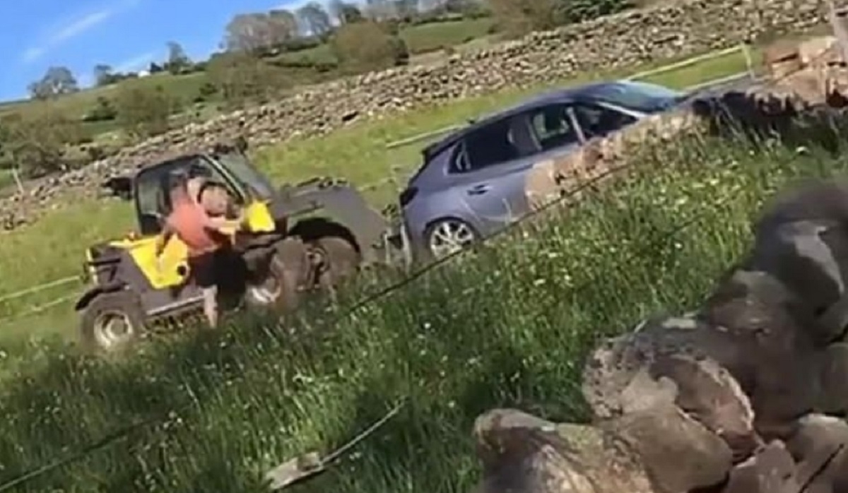 Un agriculteur en colre tasse une voiture qui bloque l'accs  son champ avec une pelle mcanique